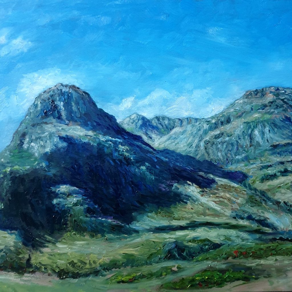 Dark mountains rising steeply either side of a valley under a bright blue sky.