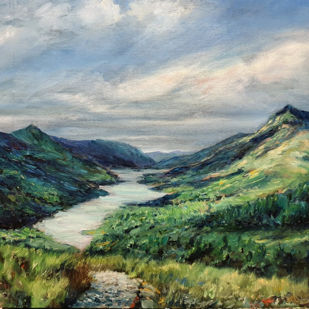Loch Leven winding between steep green hills under a clouded sky.