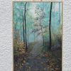 Misty Woodland on an easel against a white wall.