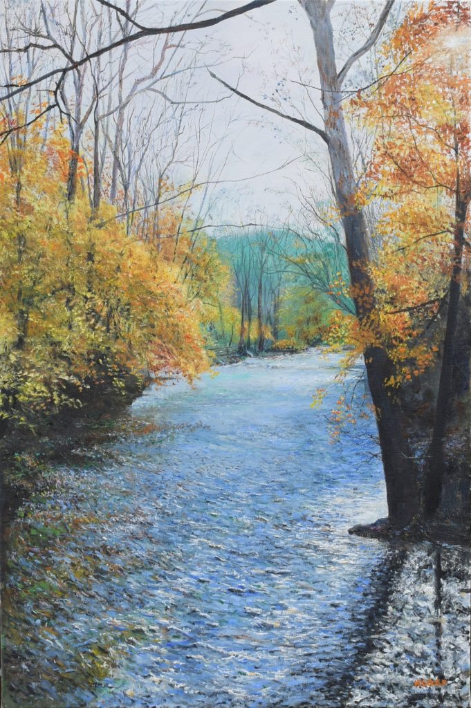 A river running between banks of gold and orange autumn trees.