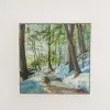 A woodland path through thawing snow, a stream running between bare trees.