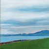 Coast: a green field above the sea, with hills on the far shore under a grey sky.