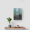 Misty Woodland on a wall above a grey chest of drawers, below a hanging lamp.