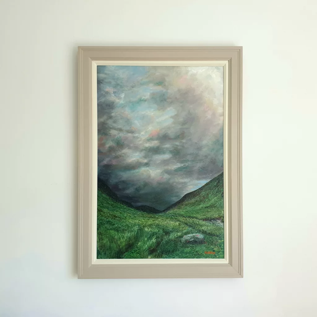A steep green glen beneath a dark, stormy sky.