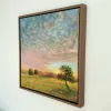Radiant in its wooden float frame, seen from the side on a white wall.