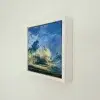 Swirling Clouds in its white float frame, seen from the side on a white wall.