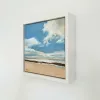 Beach in its white float frame, seen from the side on a white wall.
