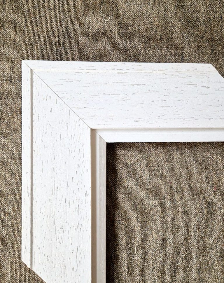 Corner of a white classic picture moulding with its inner slip
